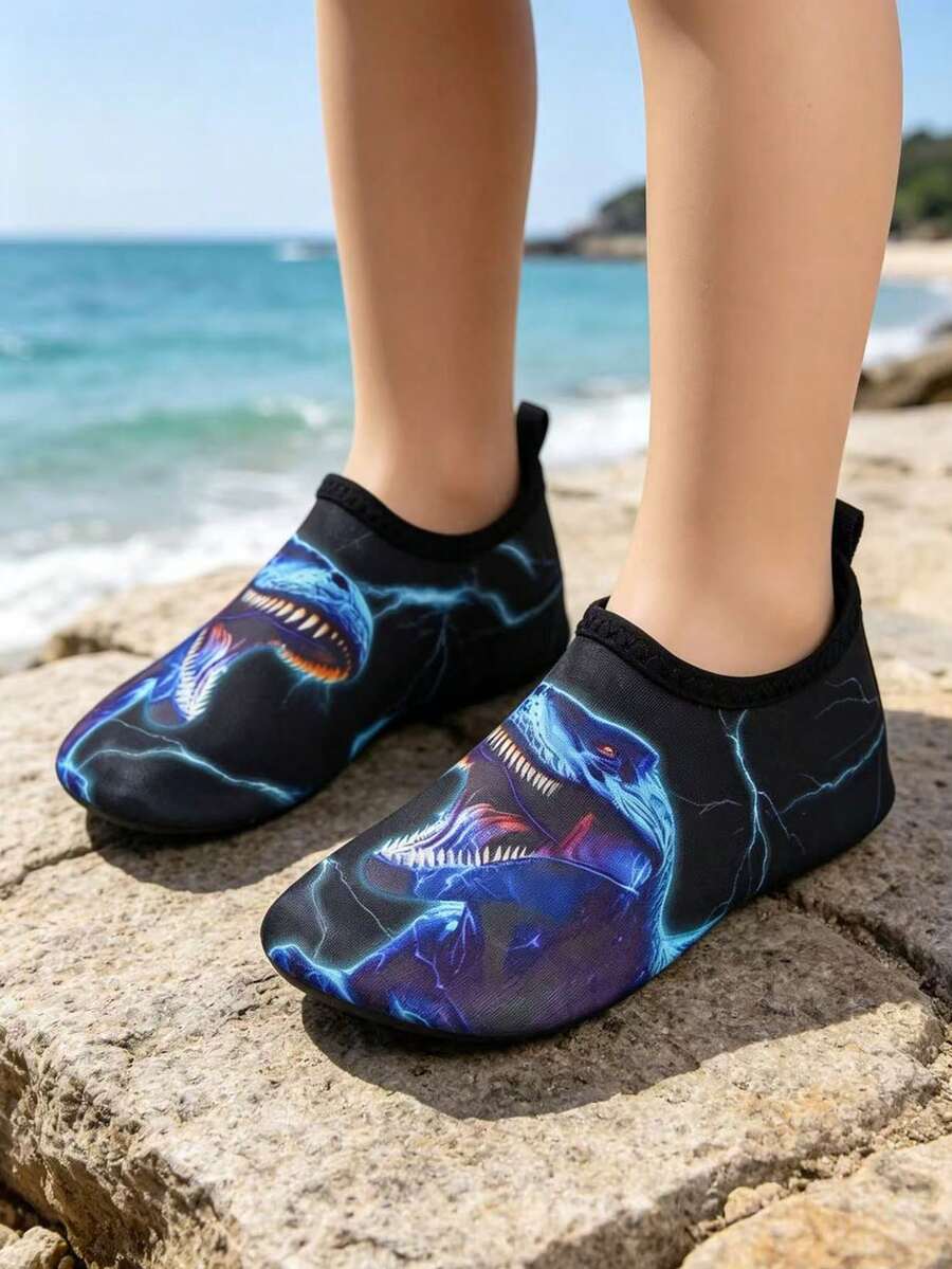 Multicolor boys water shoes featuring a cartoon Tyrannosaurus Rex print, breathable Lycra upper, slip-on stretch collar, and flexible non-slip rubber outsole.