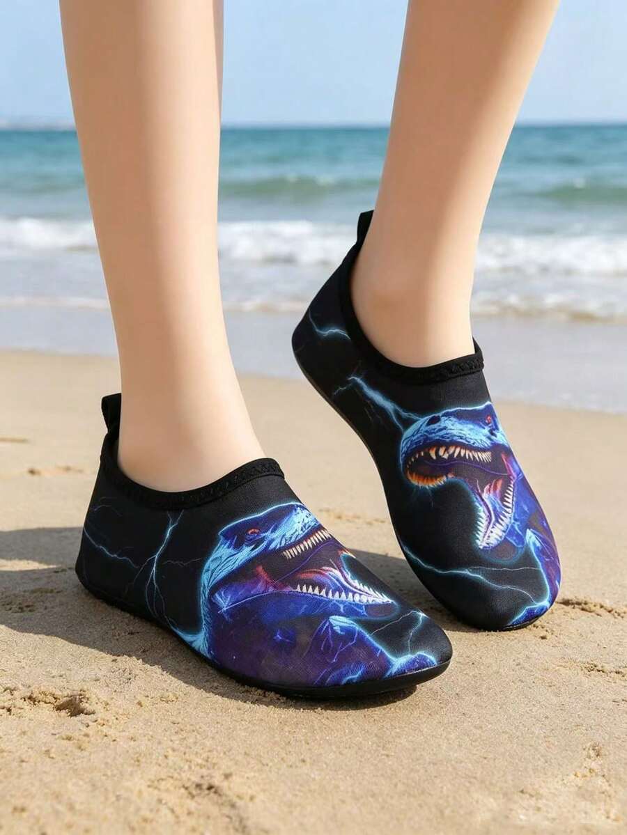 Multicolor boys water shoes featuring a cartoon Tyrannosaurus Rex print, breathable Lycra upper, slip-on stretch collar, and flexible non-slip rubber outsole.