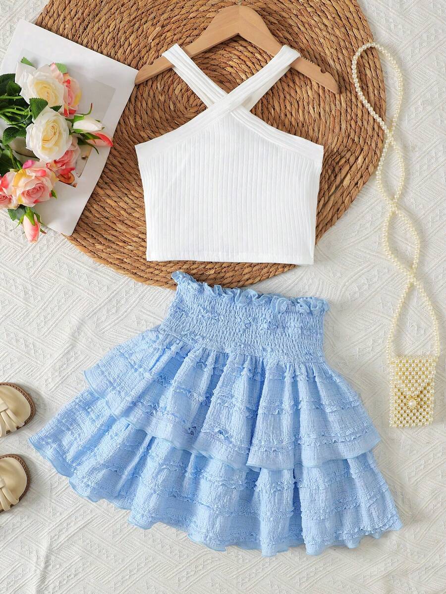 Tween girls blue and white 2-piece set with a striped halter neck vest top and a floral high-waist tiered paperbag skirt.