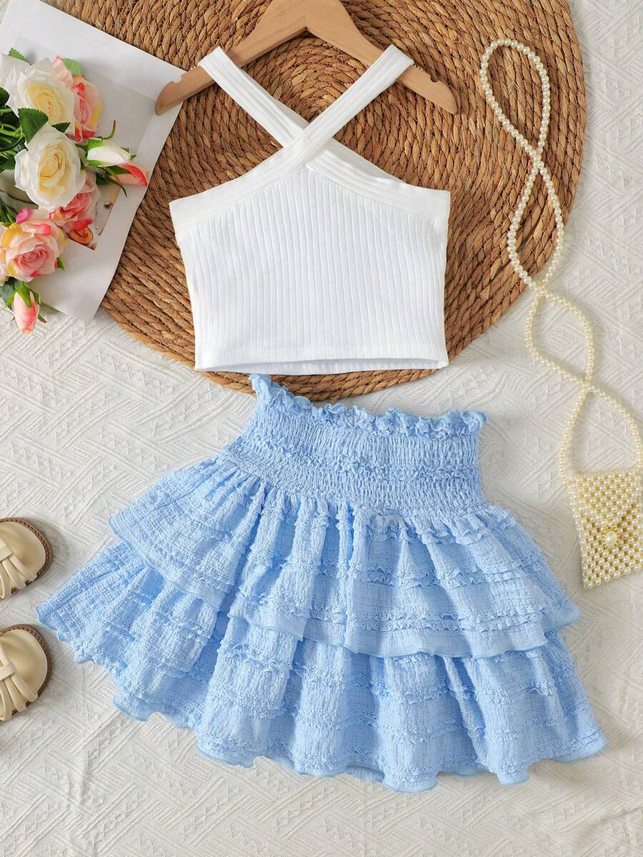 Tween girls blue and white 2-piece set with a striped halter neck vest top and a floral high-waist tiered paperbag skirt.