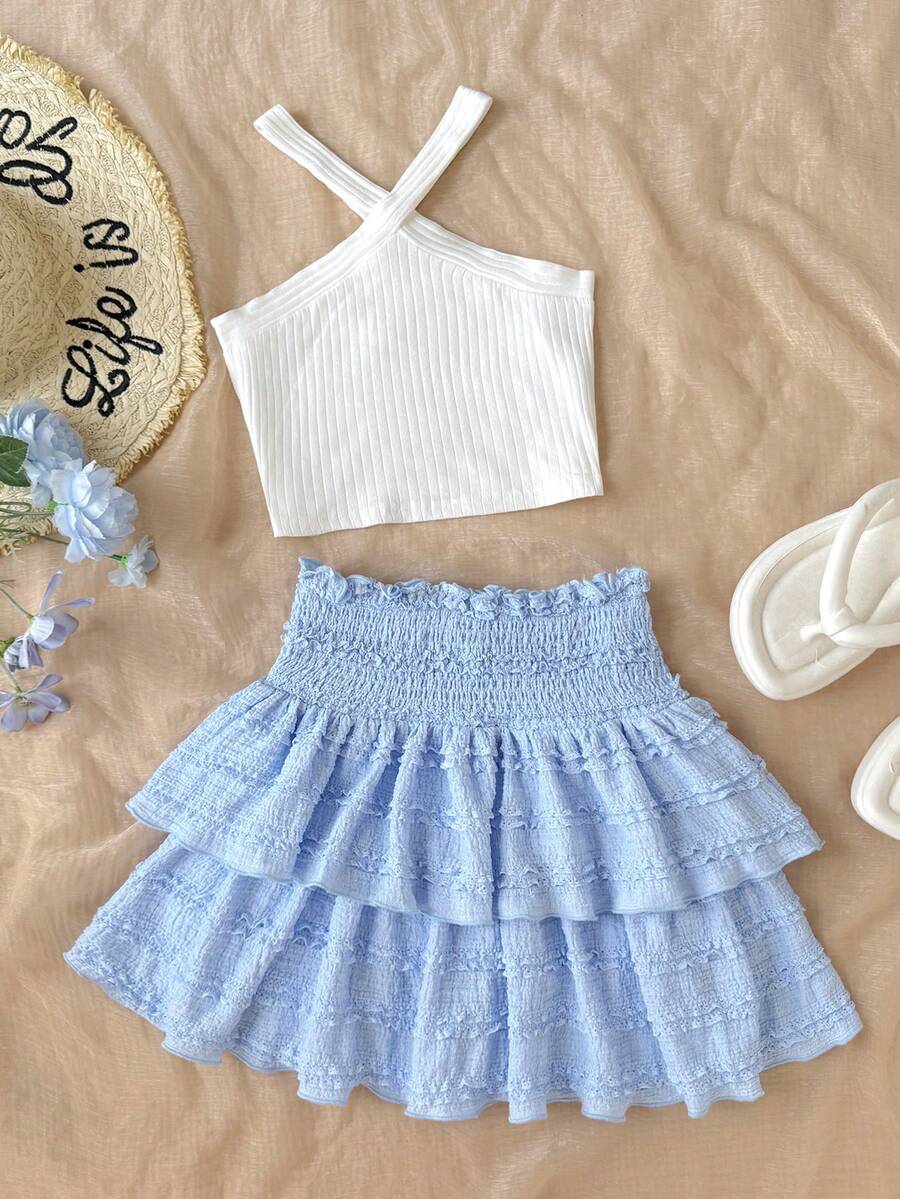 Tween girls blue and white 2-piece set with a striped halter neck vest top and a floral high-waist tiered paperbag skirt.