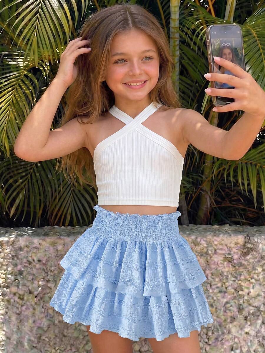 Tween girls blue and white 2-piece set with a striped halter neck vest top and a floral high-waist tiered paperbag skirt.