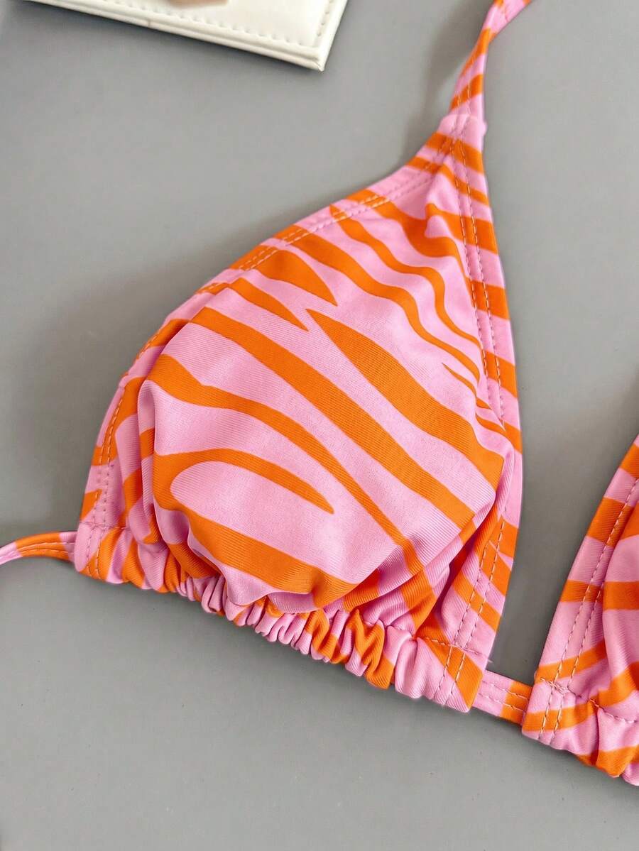 Women's black and white zebra print two-piece bikini set featuring a high waist tie-side bottom and a backless halter top with removable padding.