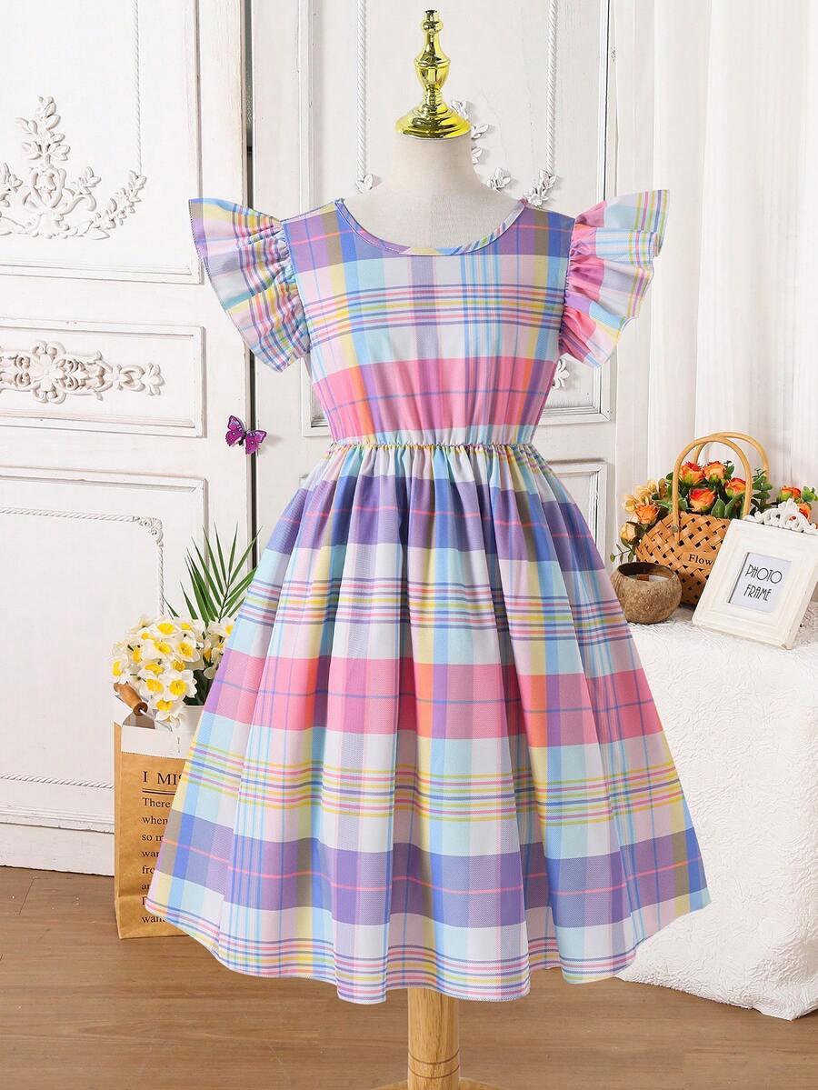 Tween girls blue short smock dress featuring flounce short sleeves, high waist flared hem, round neck, and front bow detail.