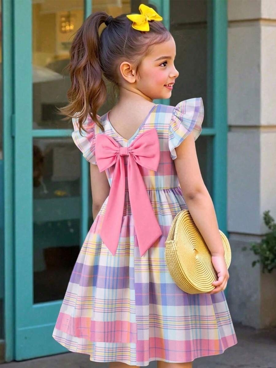 Tween girls blue short smock dress featuring flounce short sleeves, high waist flared hem, round neck, and front bow detail.