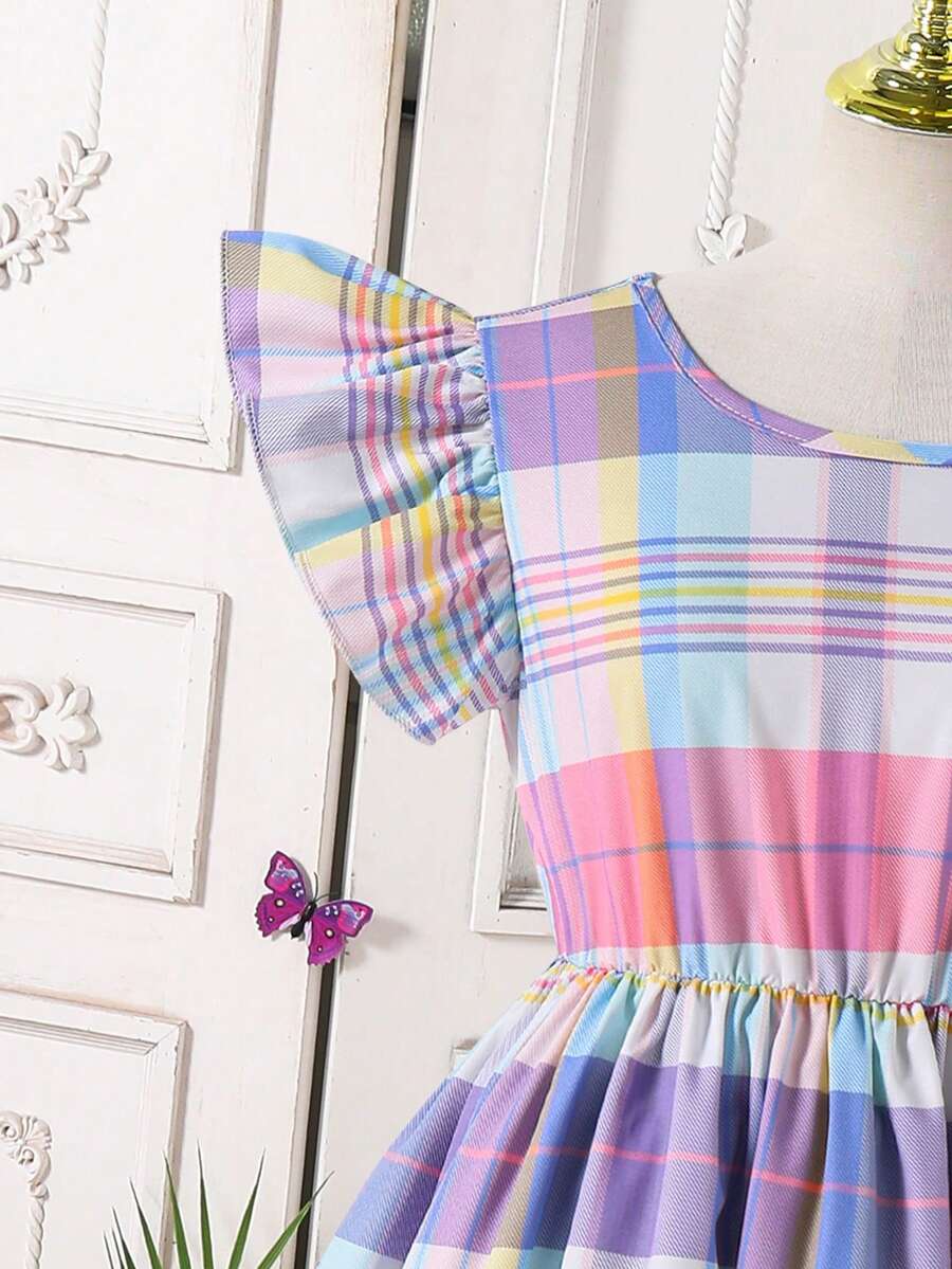Tween girls blue short smock dress featuring flounce short sleeves, high waist flared hem, round neck, and front bow detail.