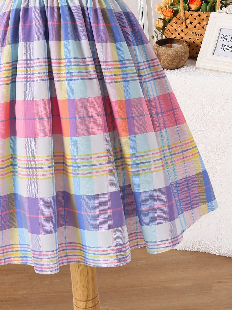 Tween girls blue short smock dress featuring flounce short sleeves, high waist flared hem, round neck, and front bow detail.