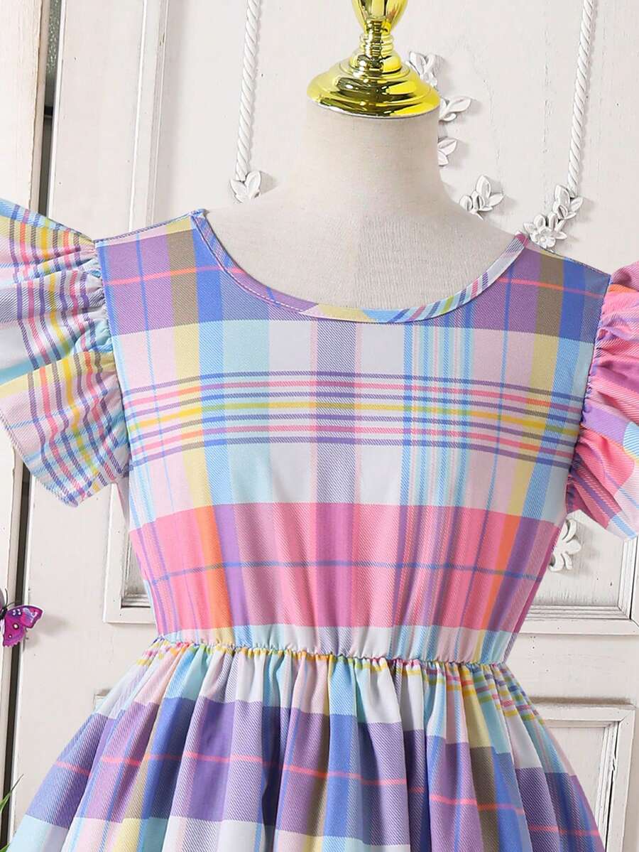 Tween girls blue short smock dress featuring flounce short sleeves, high waist flared hem, round neck, and front bow detail.