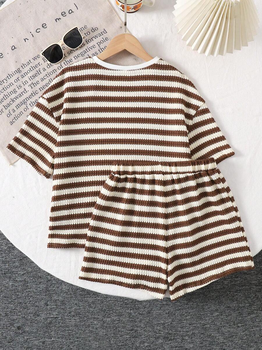 Tween girl wearing a black and white striped drop-shoulder crew neck t-shirt with bow embroidery paired with matching tie-waist shorts.