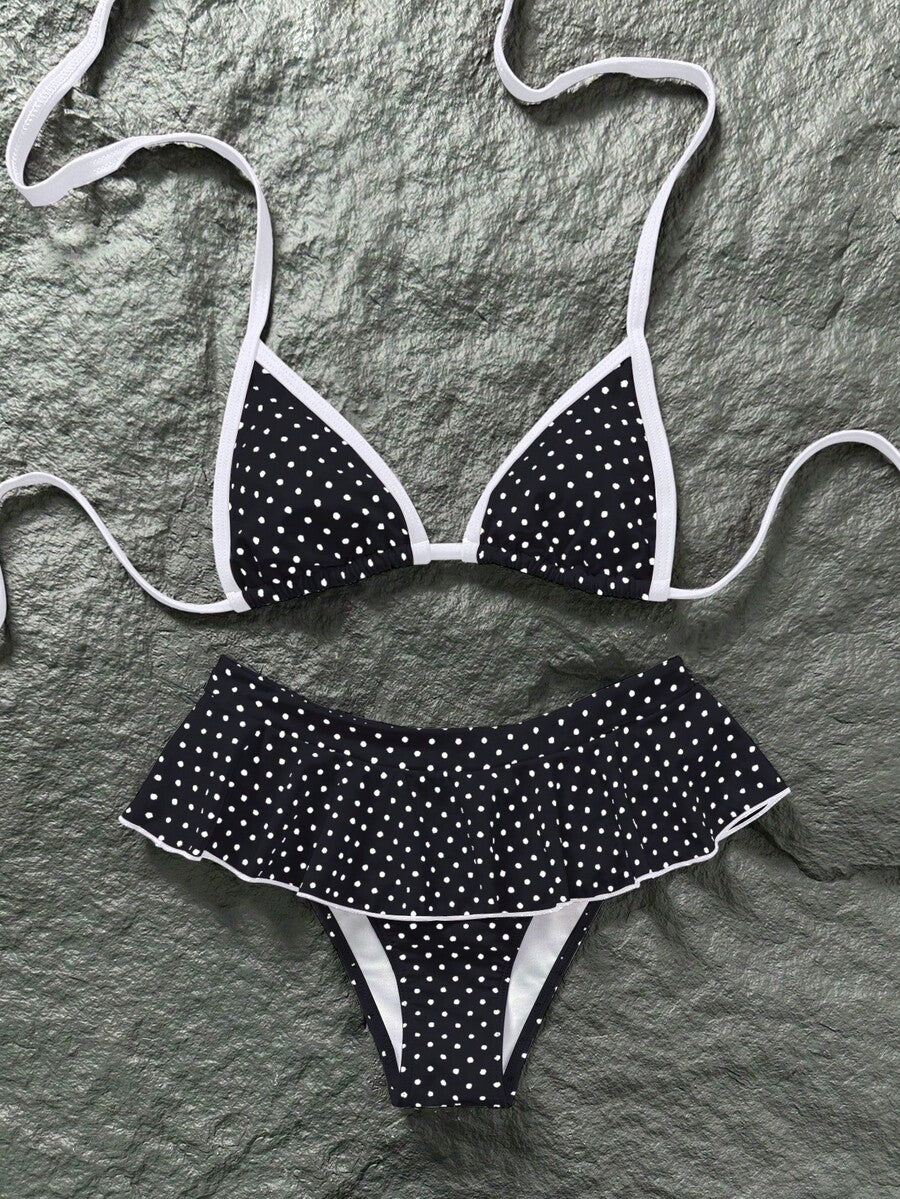 Women's 70s retro black and white polka dot bikini set featuring a halter triangle top and ultra low waist bottoms.
