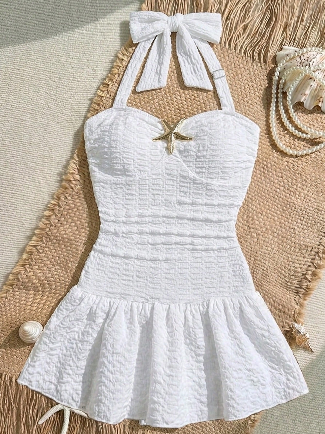 White tween girls one-piece swimsuit with textured fabric, spaghetti straps, tie bow detail, halter style, and open back for summer beachwear.
