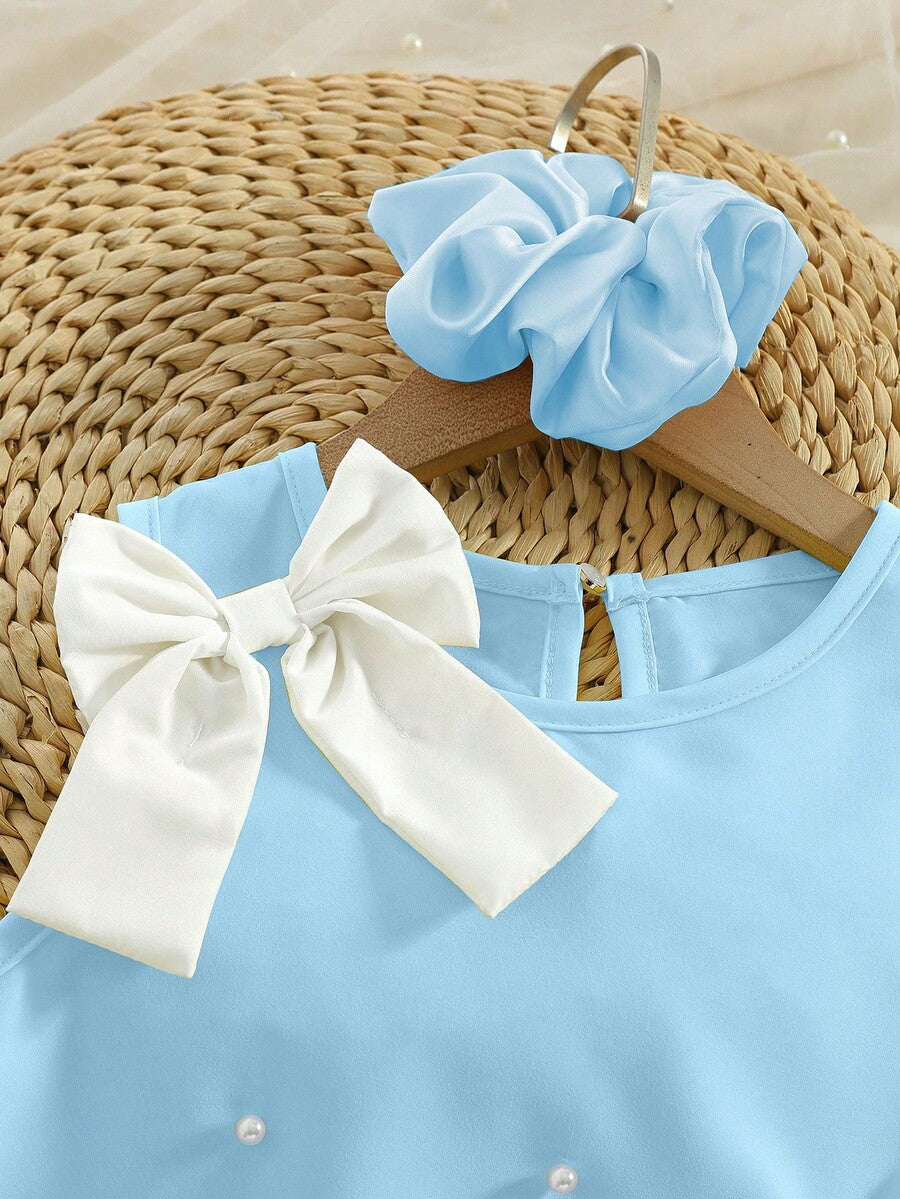 Yellow sleeveless colorblock dress for girls featuring a round neck, ruffle hem, and front bow detail.