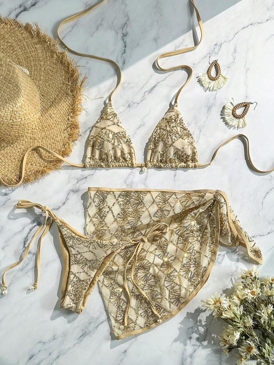 Women's 3-piece blue tropical shell print bikini set featuring a halter bralette top, low-waist tie-side bottom, and a matching sheer mesh cover-up skirt.