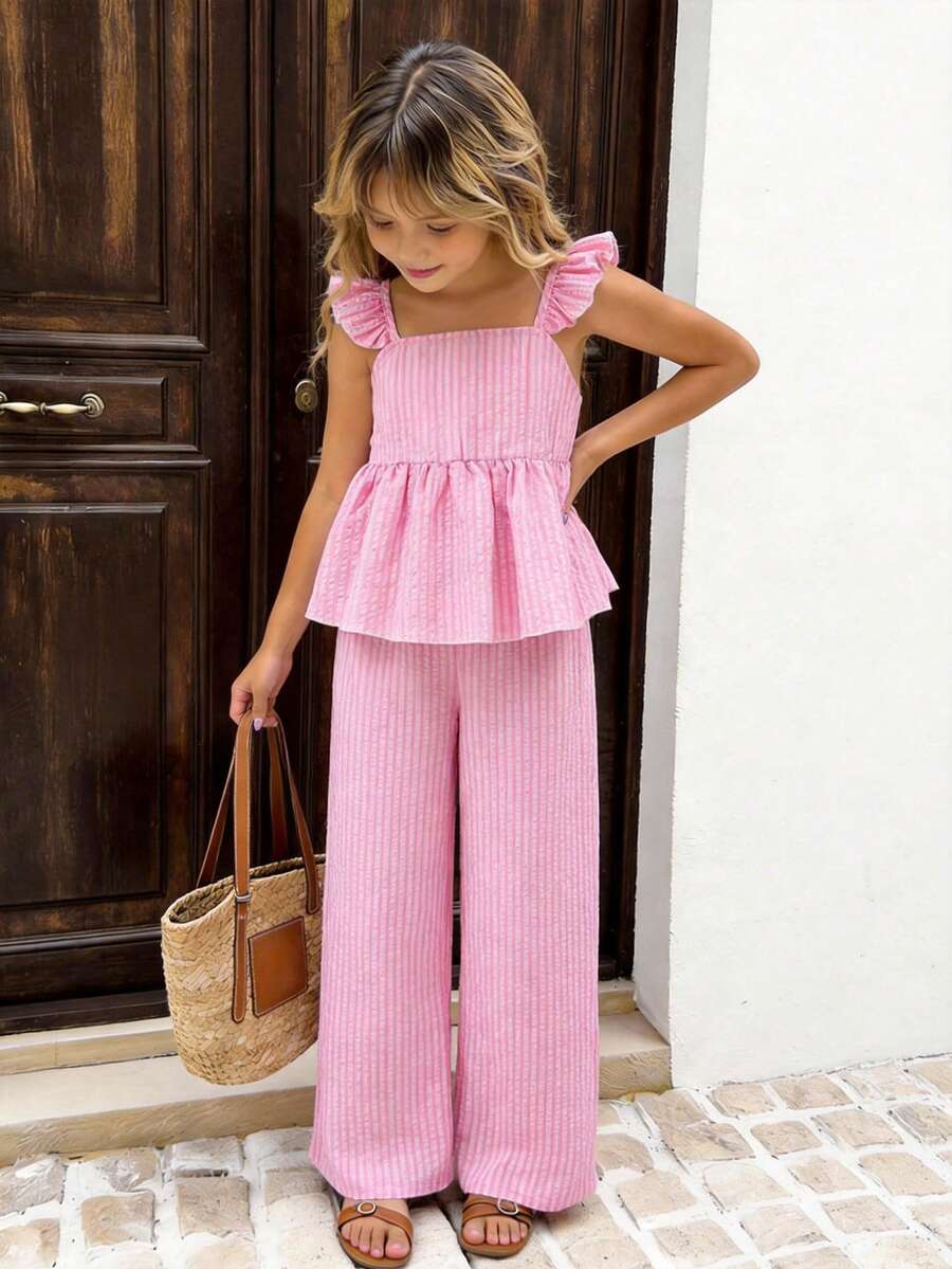 Tween girl wearing an apricot 2-piece outfit set featuring a shirred spaghetti strap short cami top and matching wide-leg long pants.
