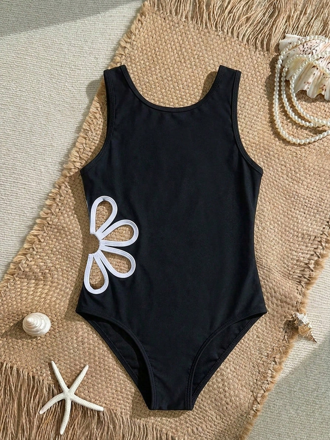 Tween girl one-piece swimsuit with scoop neck, cut-out detail, contrast trim, plant pattern, fitted silhouette, and black and white design for summer beachwear.