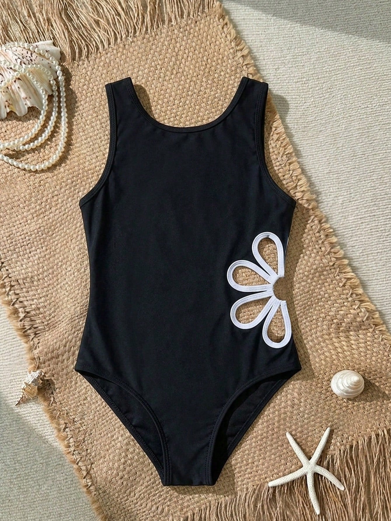 Tween girl one-piece swimsuit with scoop neck, cut-out detail, contrast trim, plant pattern, fitted silhouette, and black and white design for summer beachwear.