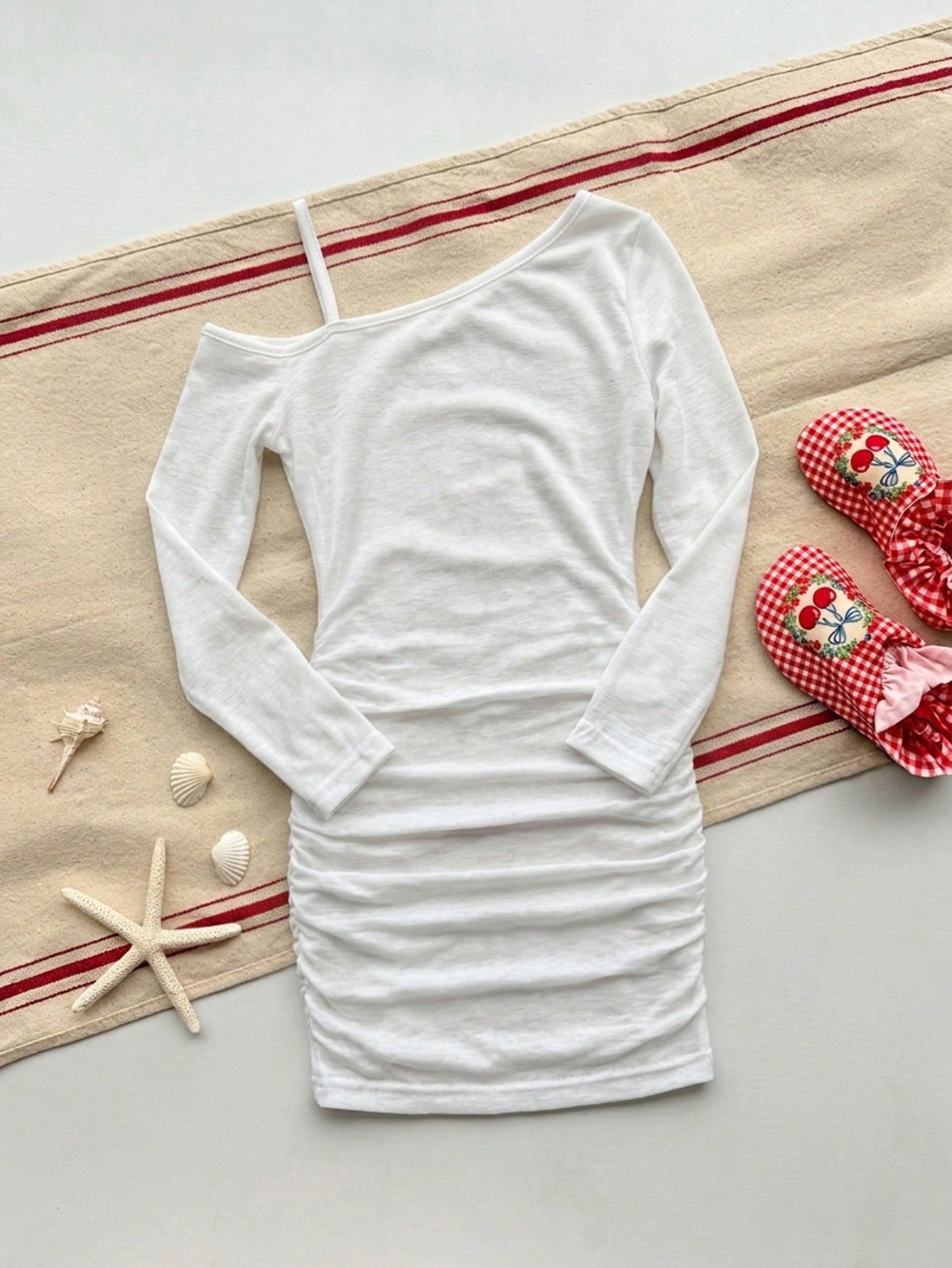 Girls plus size one-piece swimsuit in white with striped pattern, asymmetric neckline, long sleeves, fitted shape, and skirt-style bottom.