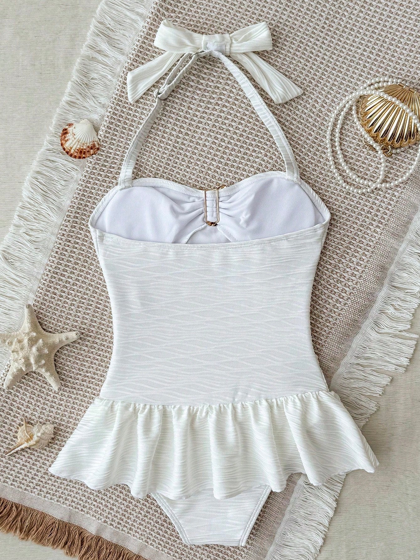 White tween girls one-piece swimsuit with textured fabric, spaghetti straps, tie bow detail, halter style, and open back for summer beachwear.