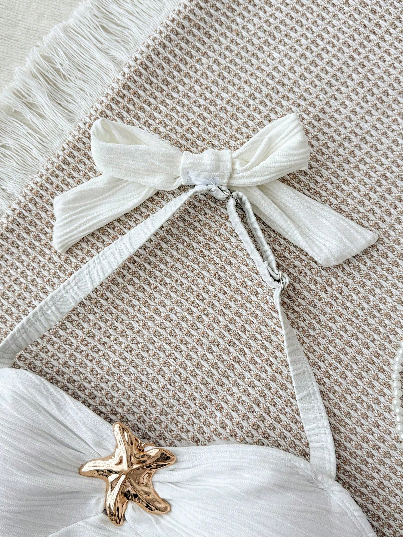 White tween girls one-piece swimsuit with textured fabric, spaghetti straps, tie bow detail, halter style, and open back for summer beachwear.