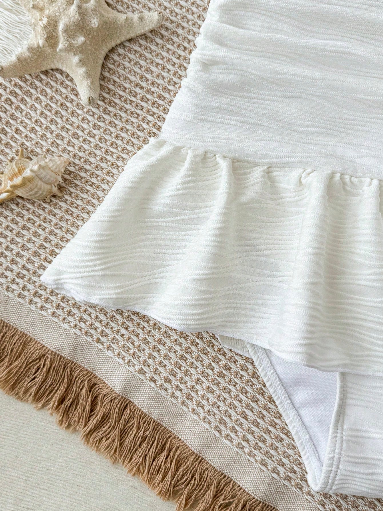 White tween girls one-piece swimsuit with textured fabric, spaghetti straps, tie bow detail, halter style, and open back for summer beachwear.