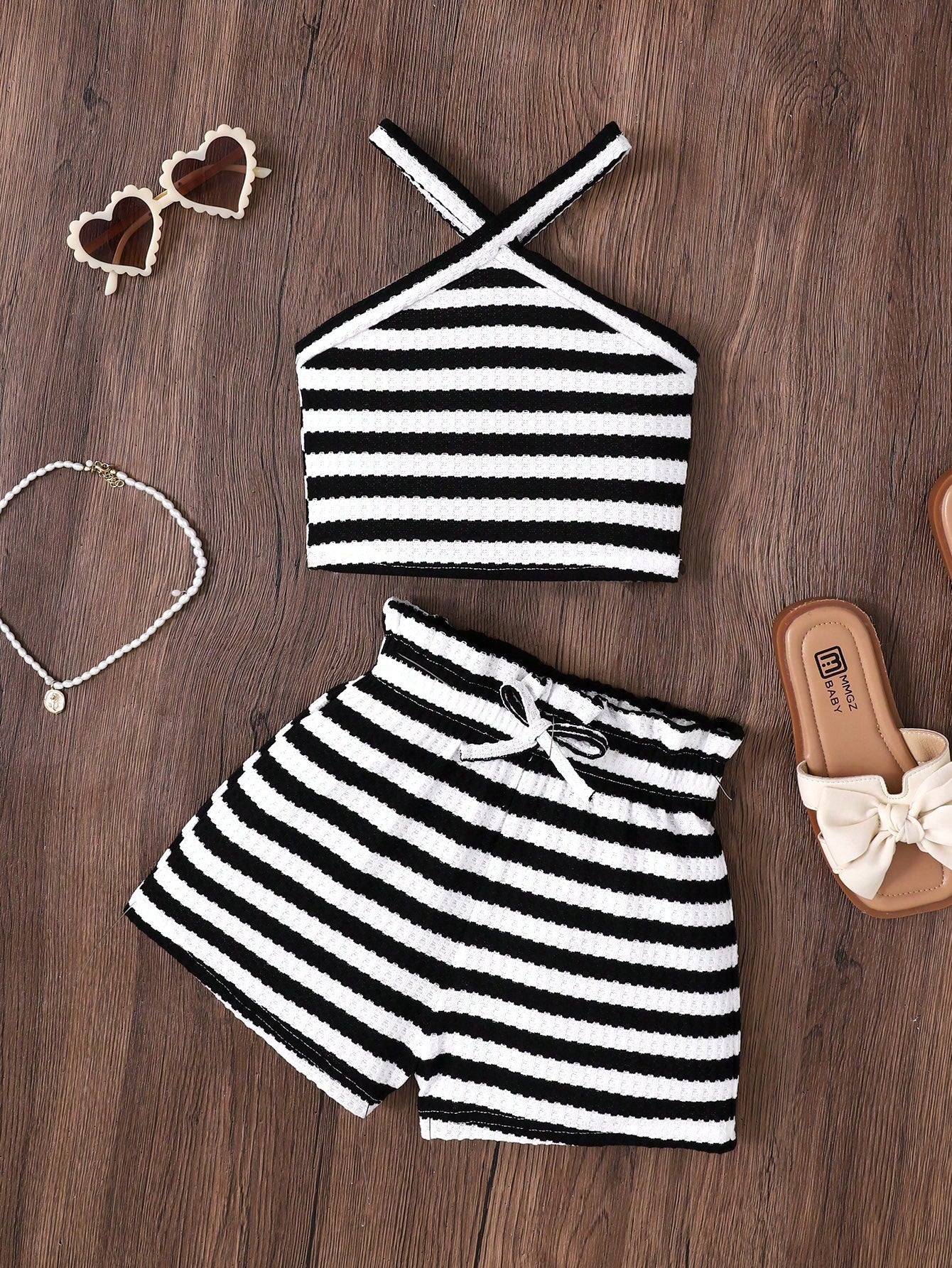 Black and white striped 2-piece set for tween girls featuring a halter sleeveless pullover top with criss-cross knot detail and matching paperbag waist shorts.