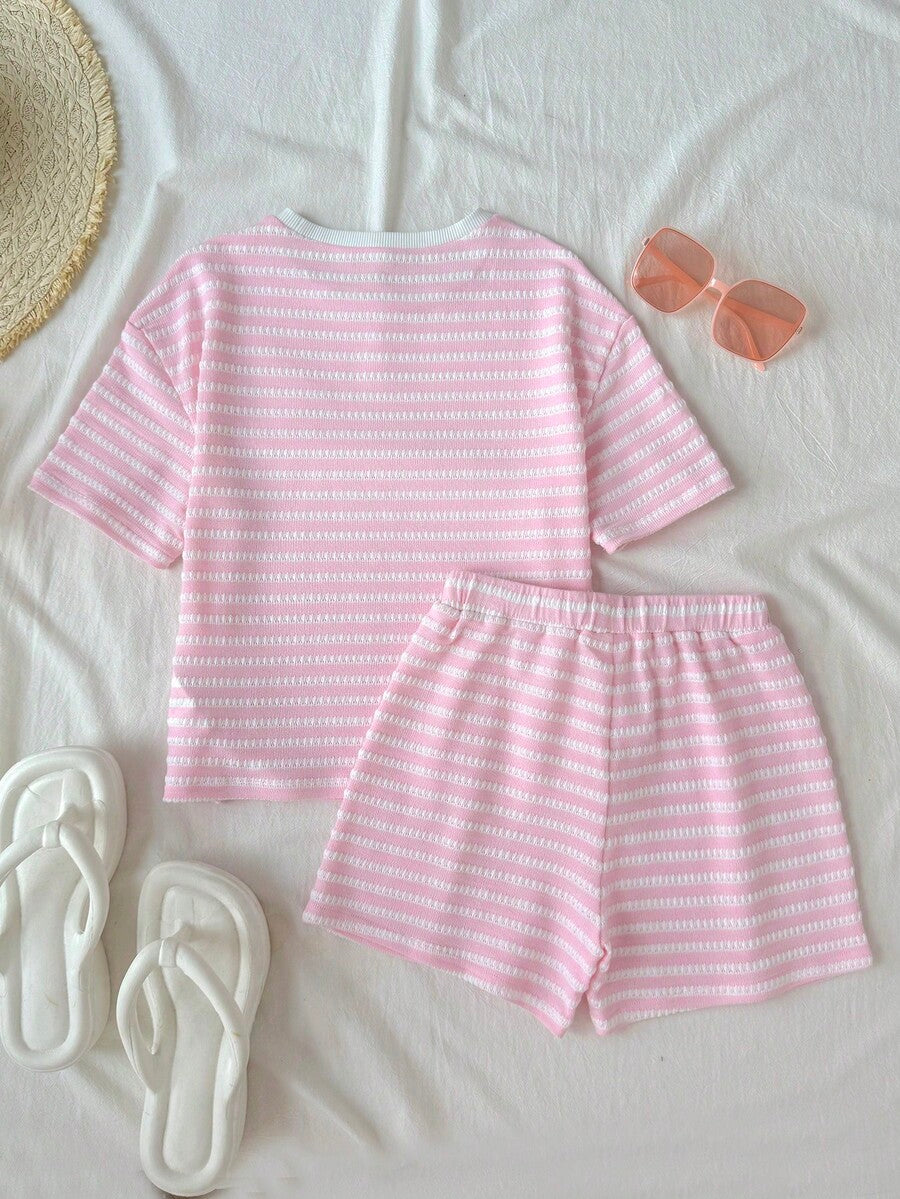 Tween girl wearing a black and white striped drop-shoulder crew neck t-shirt with bow embroidery paired with matching tie-waist shorts.