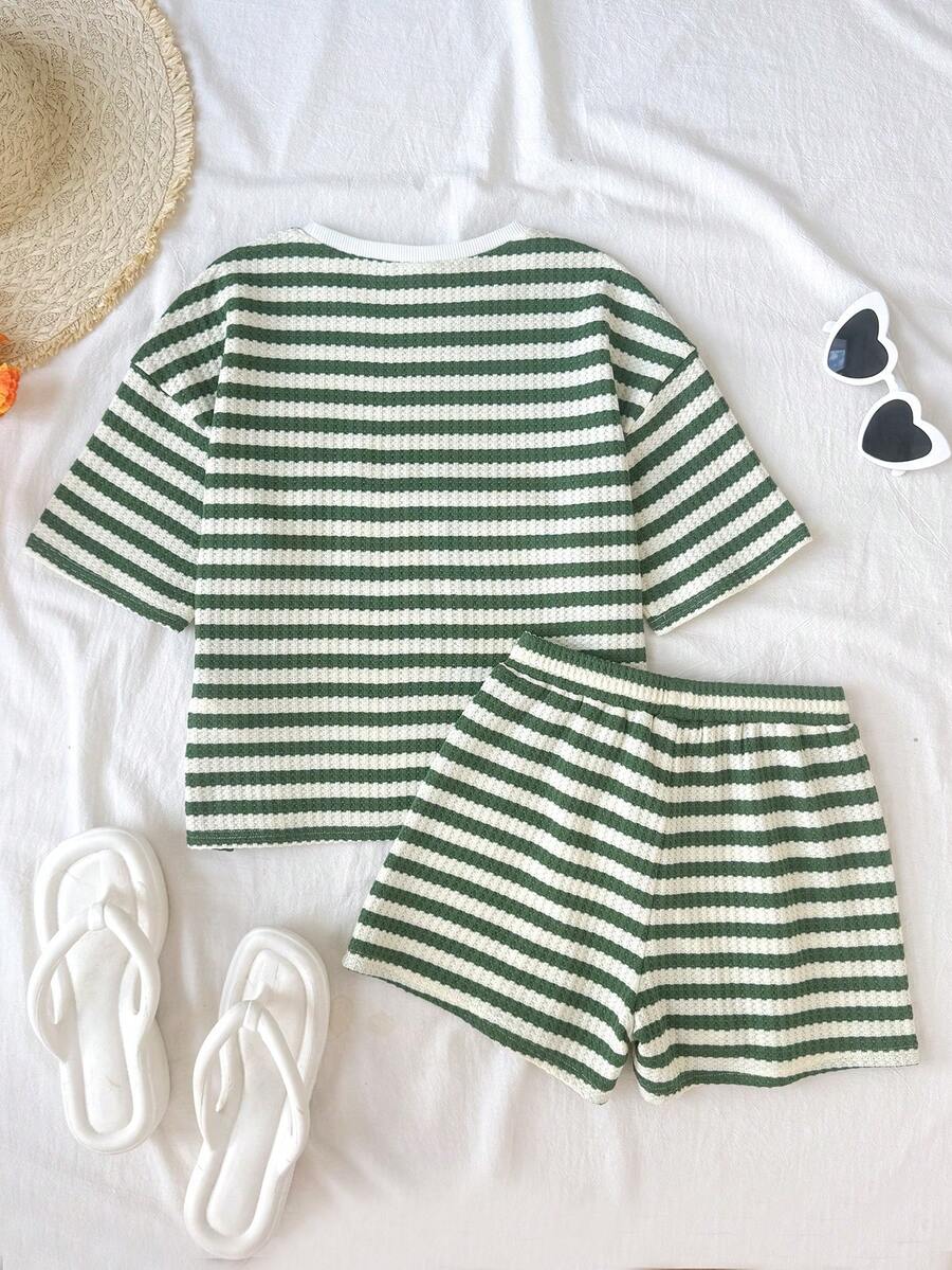 Tween girl wearing a black and white striped drop-shoulder crew neck t-shirt with bow embroidery paired with matching tie-waist shorts.