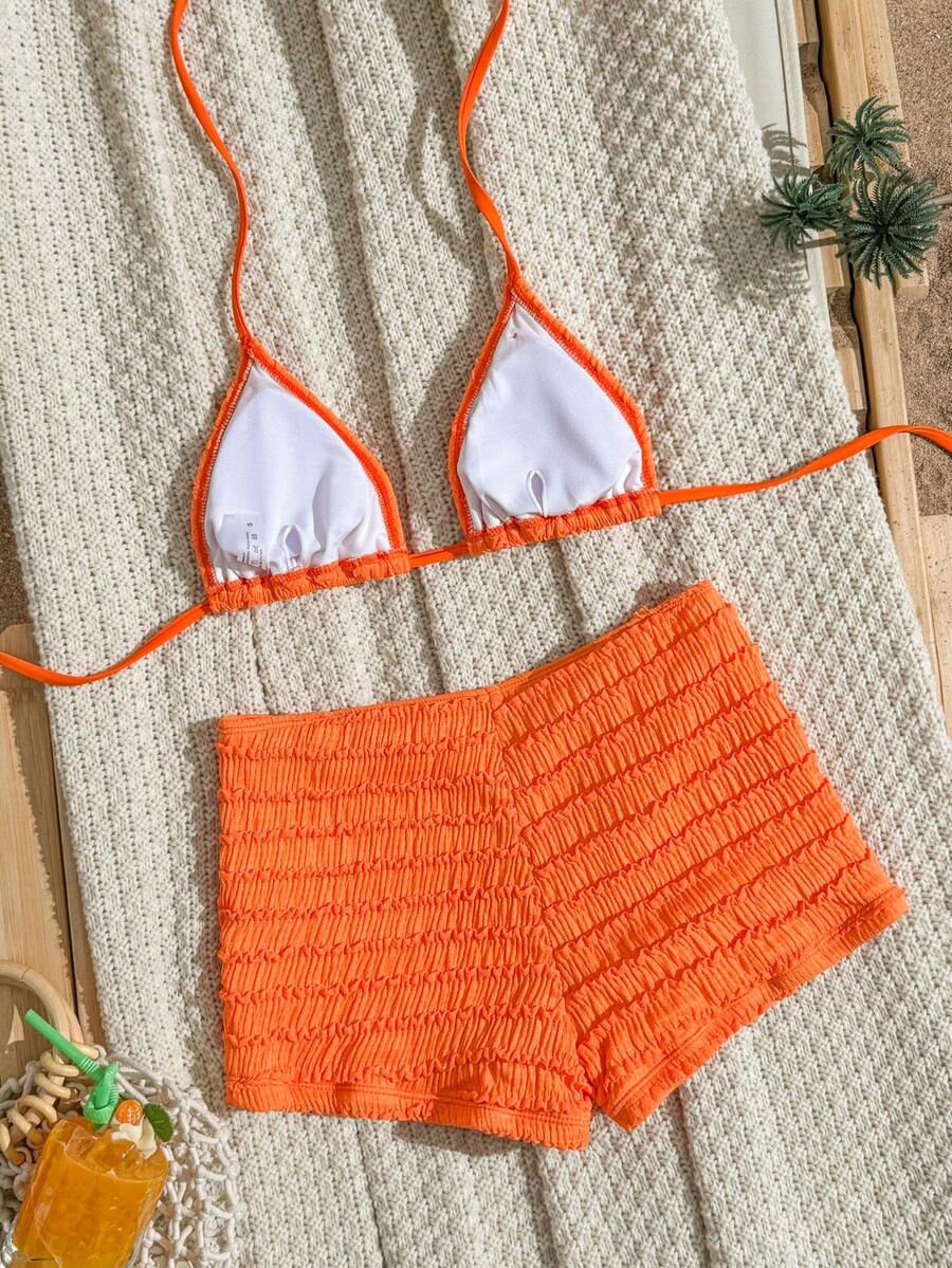 Women's apricot two-piece swimsuit set with a halter tie-back top and matching high stretch shorts.
