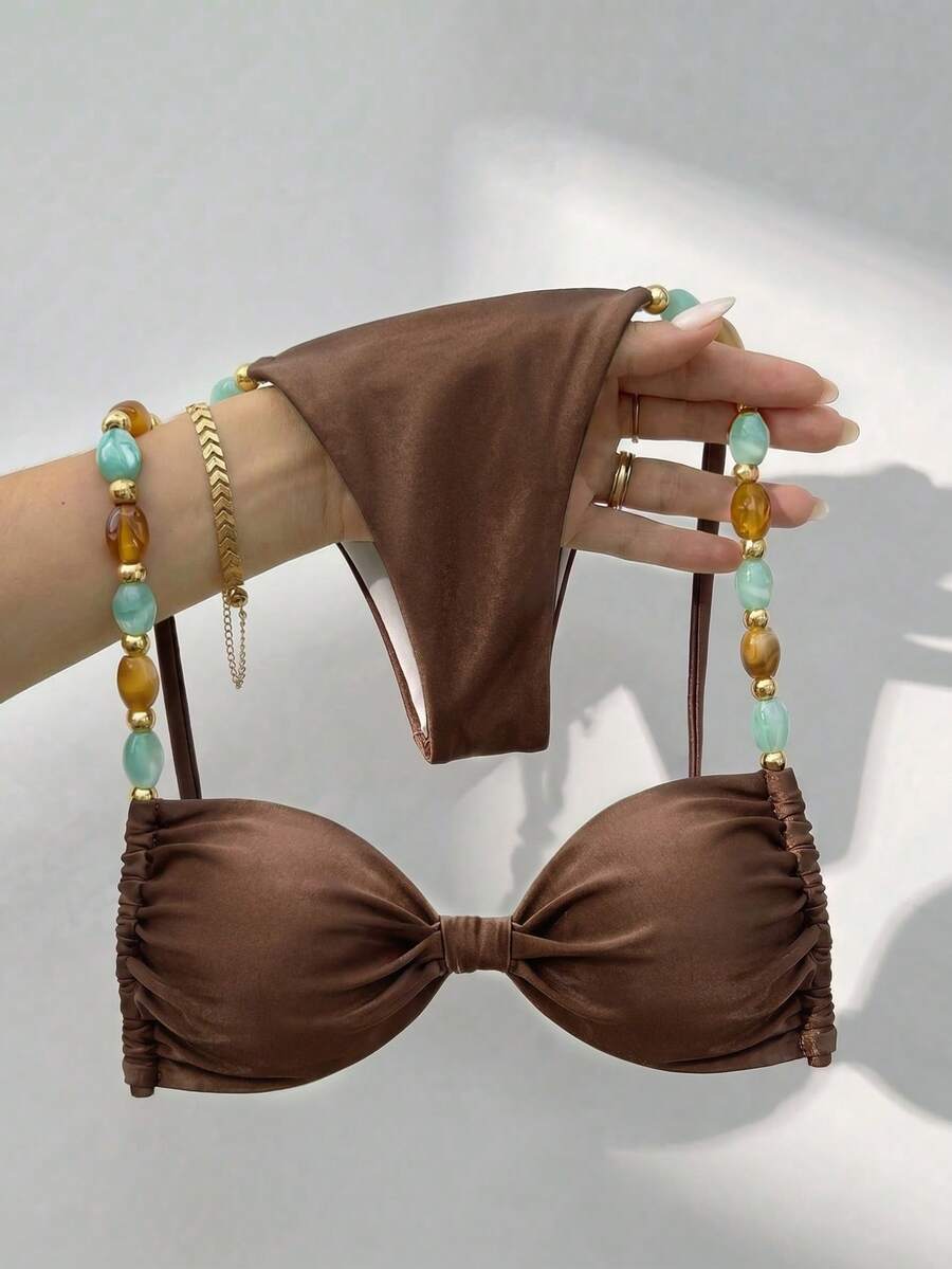 Women's green halter neck bikini set featuring color-block beaded shoulder straps, back tie detail, and high cut bottoms.