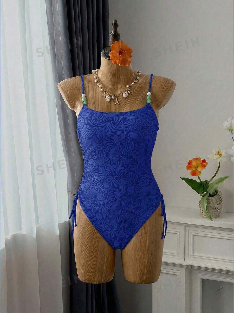Women's blue backless one-piece swimsuit featuring spaghetti straps, wireless bra with removable padding, and drawstring details.