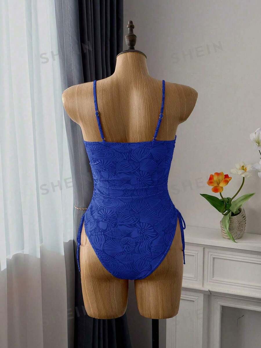 Women's blue backless one-piece swimsuit featuring spaghetti straps, wireless bra with removable padding, and drawstring details.