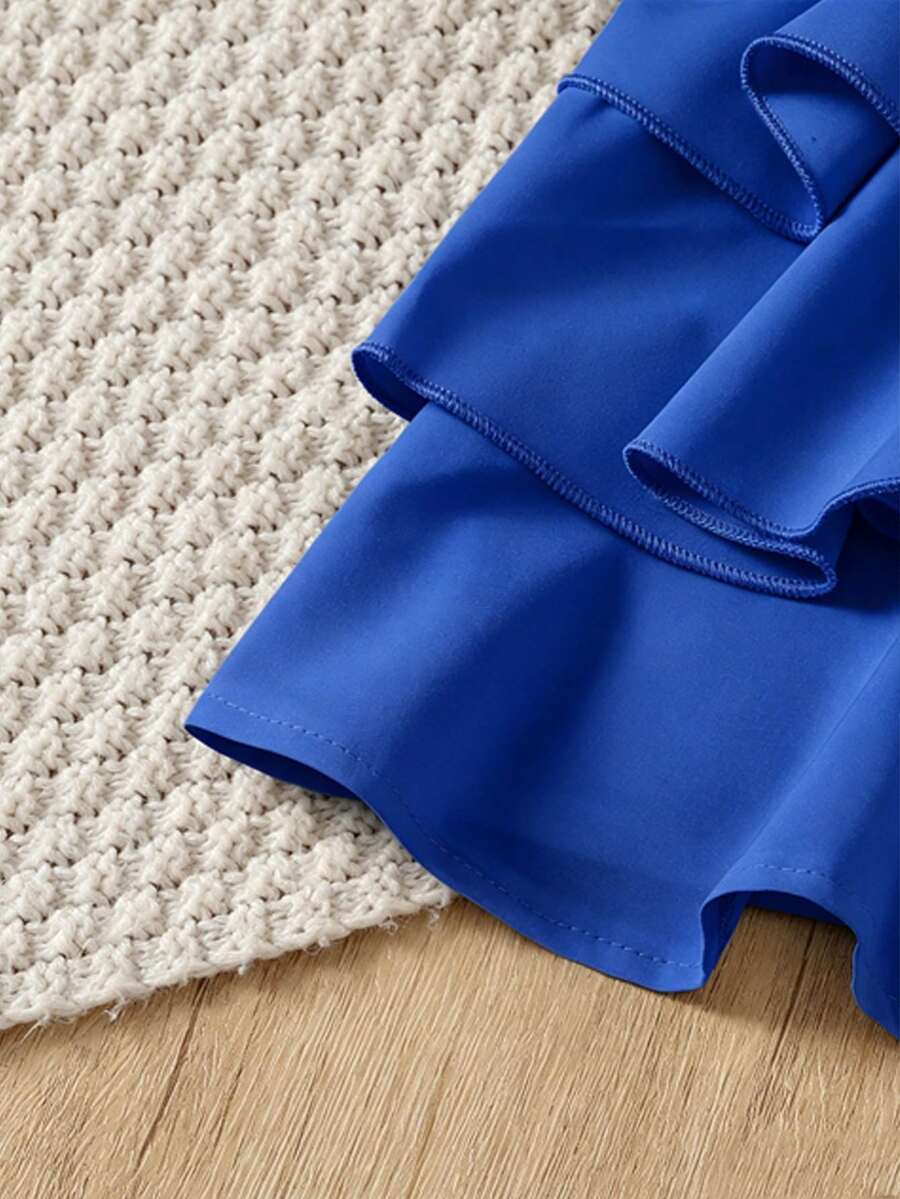 Tween girls blue 2-piece vacation outfit set featuring a tiered ruffle spaghetti strap camisole and loose high-waist pants.