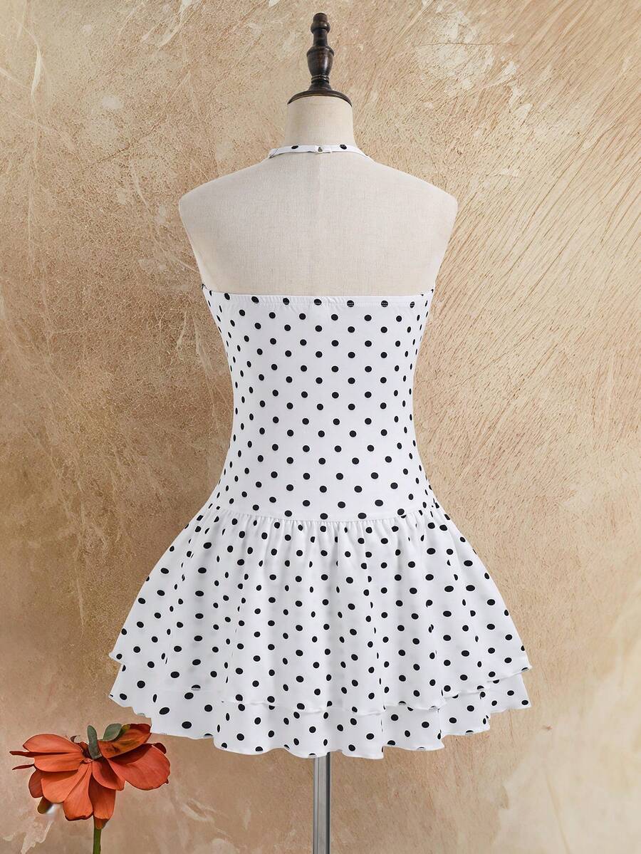 Tween girl black mini dress with halter neckline, backless design, tiered layer detail, high waist, flounce hem, and sleeveless slim fit.