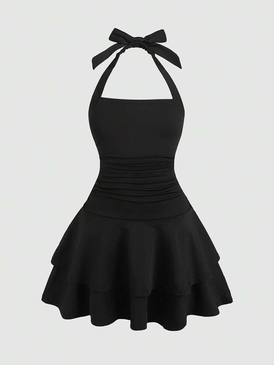 Black sleeveless halter polka dot mini dress for tween girls featuring a high waist and flared hem