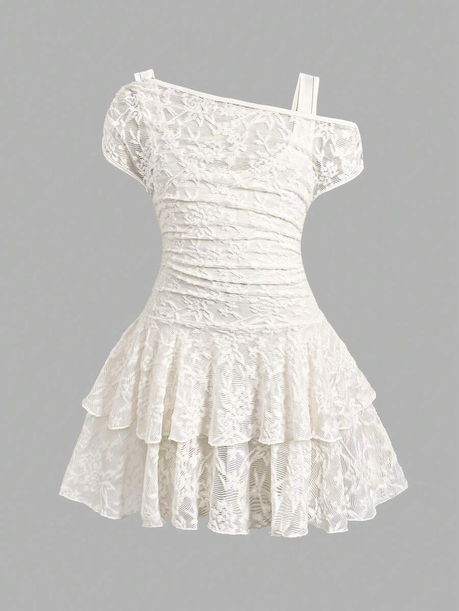 Tween girl wearing an apricot asymmetric skater dress with ruffle and applique details for party and formal occasions.