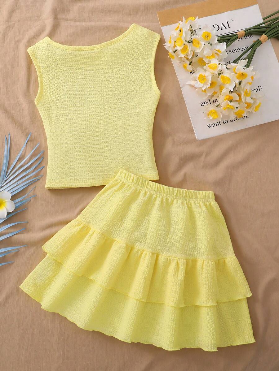 Light blue two-piece outfit set for tween girls with a sleeveless round neck vest top and a tiered ruffle cake skirt featuring a plant pattern.