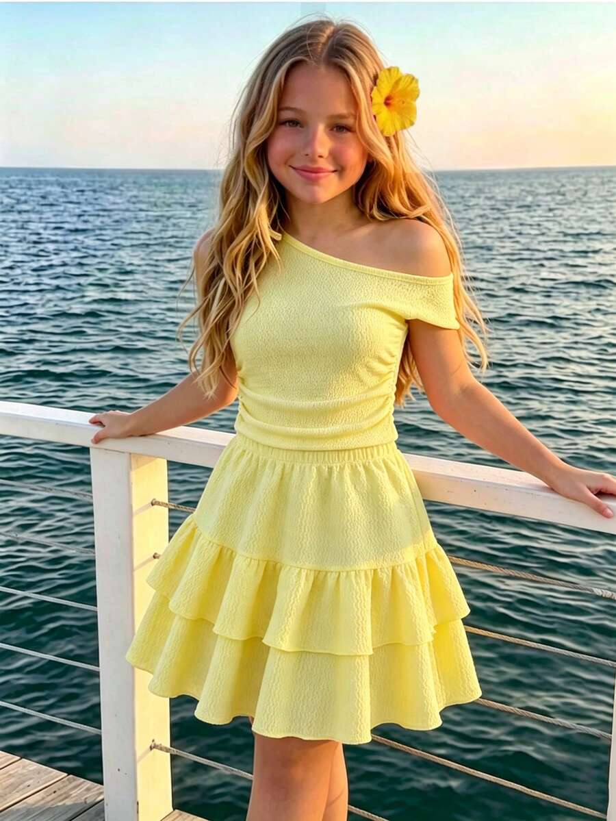 Light blue two-piece outfit set for tween girls with a sleeveless round neck vest top and a tiered ruffle cake skirt featuring a plant pattern.