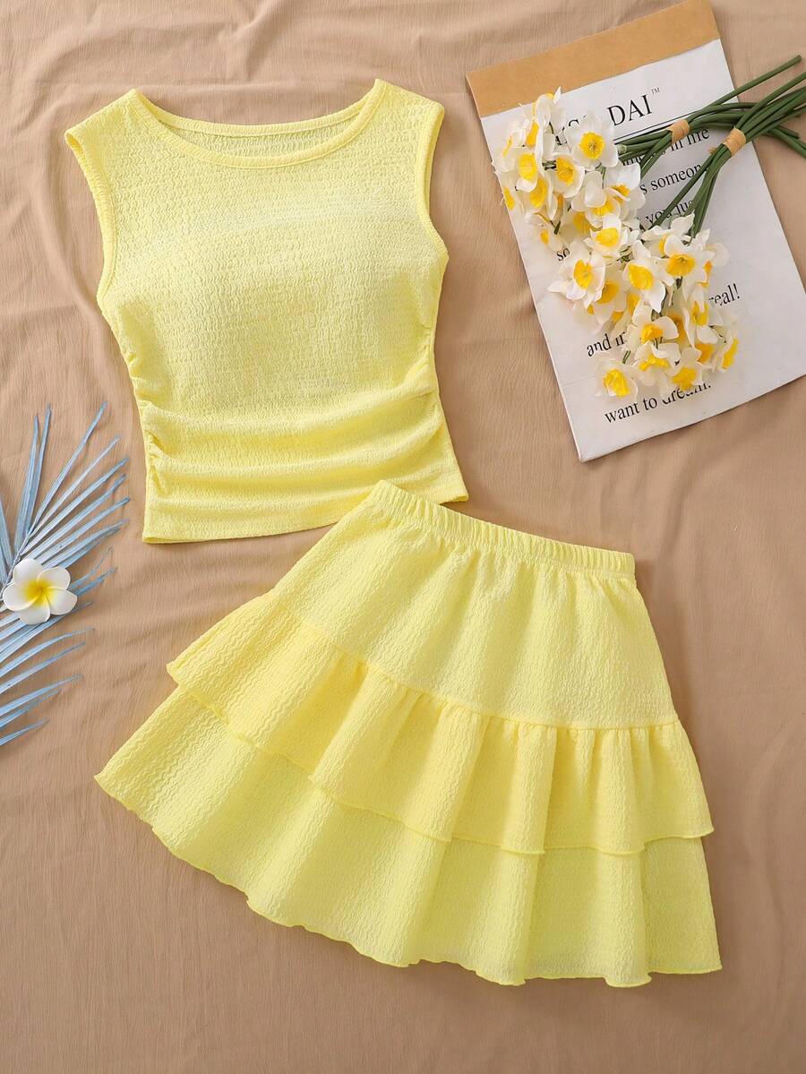 Light blue two-piece outfit set for tween girls with a sleeveless round neck vest top and a tiered ruffle cake skirt featuring a plant pattern.