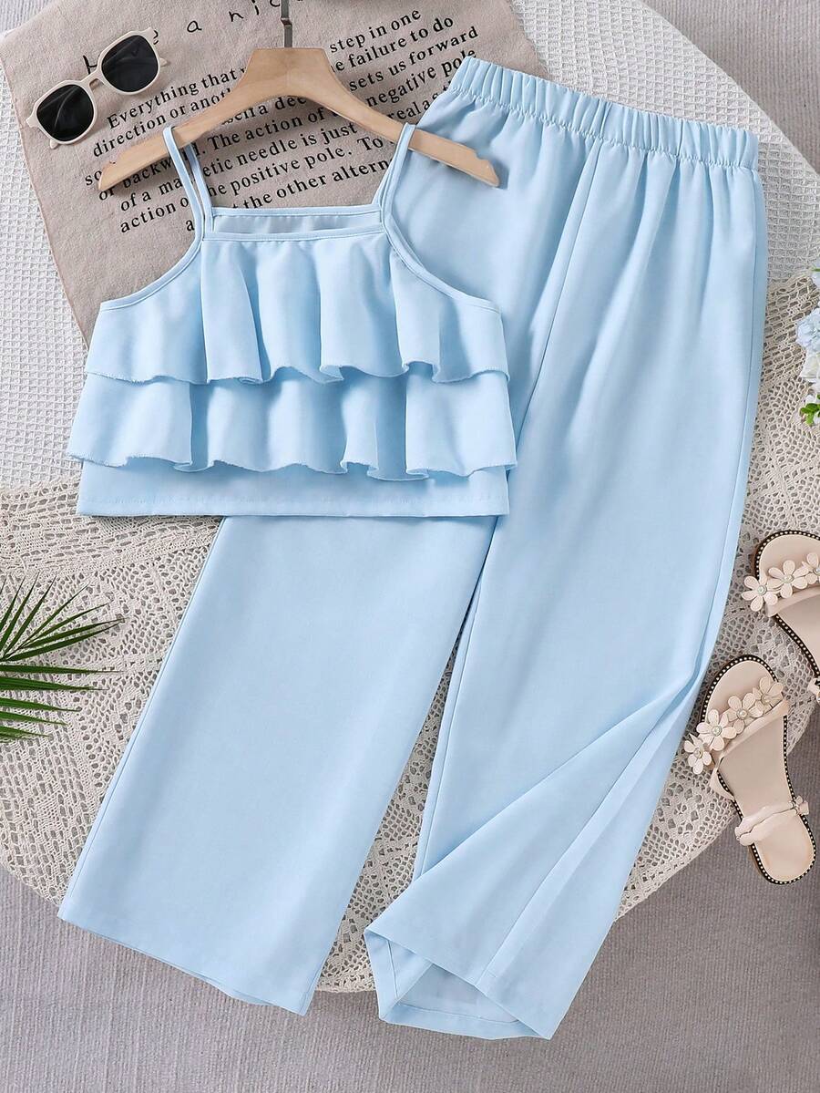 Tween girls blue 2-piece vacation outfit set featuring a tiered ruffle spaghetti strap camisole and loose high-waist pants.