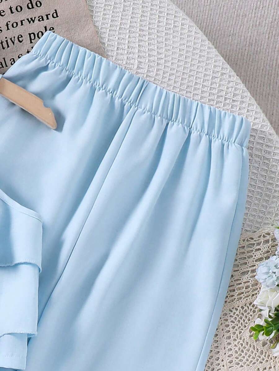 Tween girls blue 2-piece vacation outfit set featuring a tiered ruffle spaghetti strap camisole and loose high-waist pants.