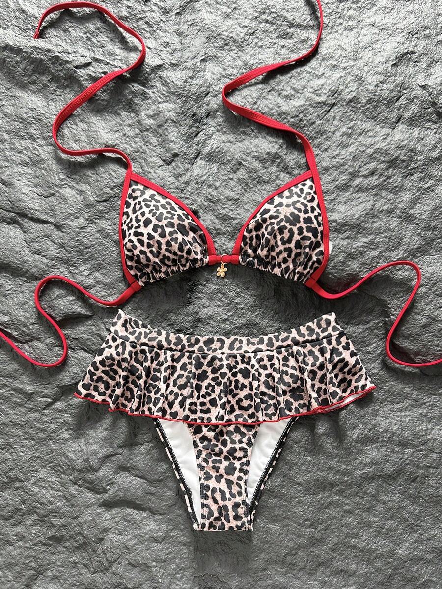 Women's 70s retro black and white polka dot bikini set featuring a halter triangle top and ultra low waist bottoms.