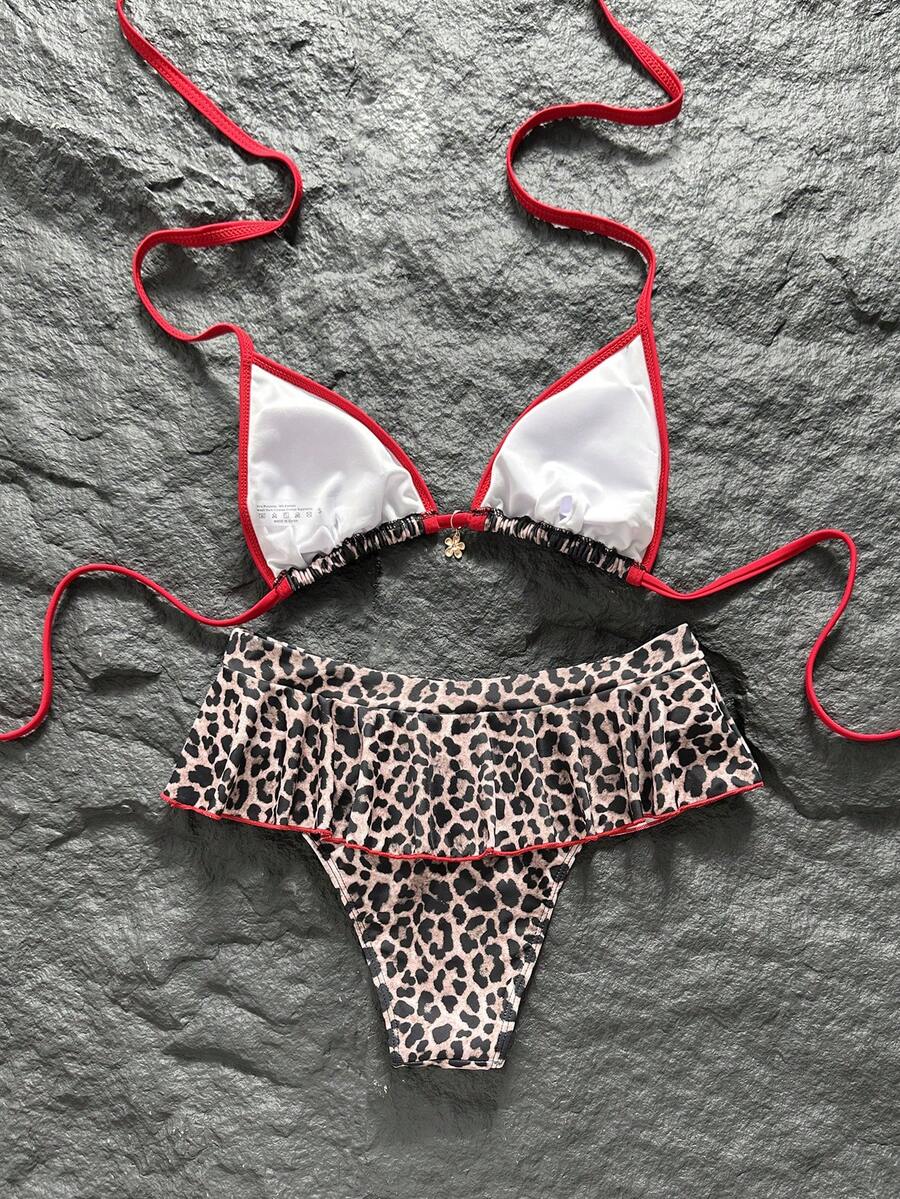 Women's 70s retro black and white polka dot bikini set featuring a halter triangle top and ultra low waist bottoms.
