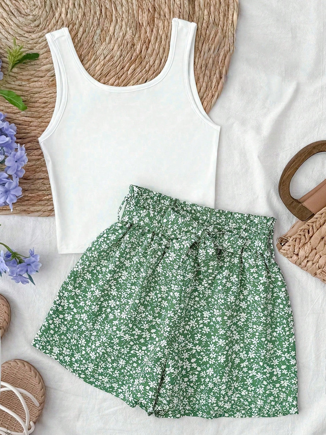 Tween girl summer two-piece outfit featuring a white scoop neck tank top and green ditsy floral print paperbag waist shorts with belt.