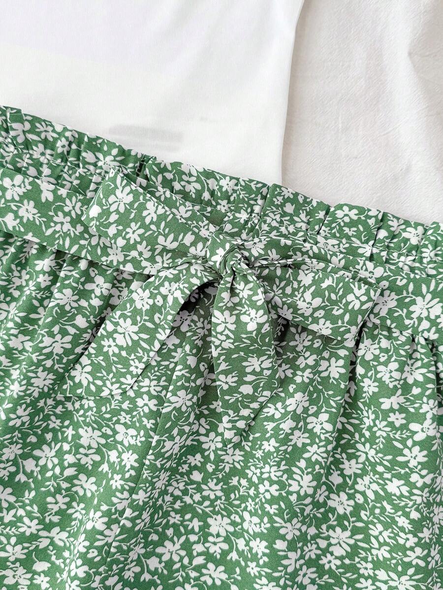 Tween girl summer two-piece outfit featuring a white scoop neck tank top and green ditsy floral print paperbag waist shorts with belt.