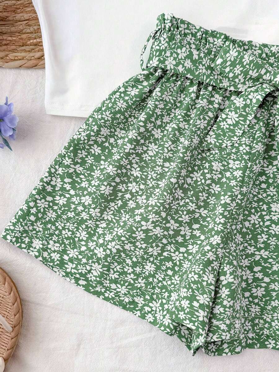 Tween girl summer two-piece outfit featuring a white scoop neck tank top and green ditsy floral print paperbag waist shorts with belt.
