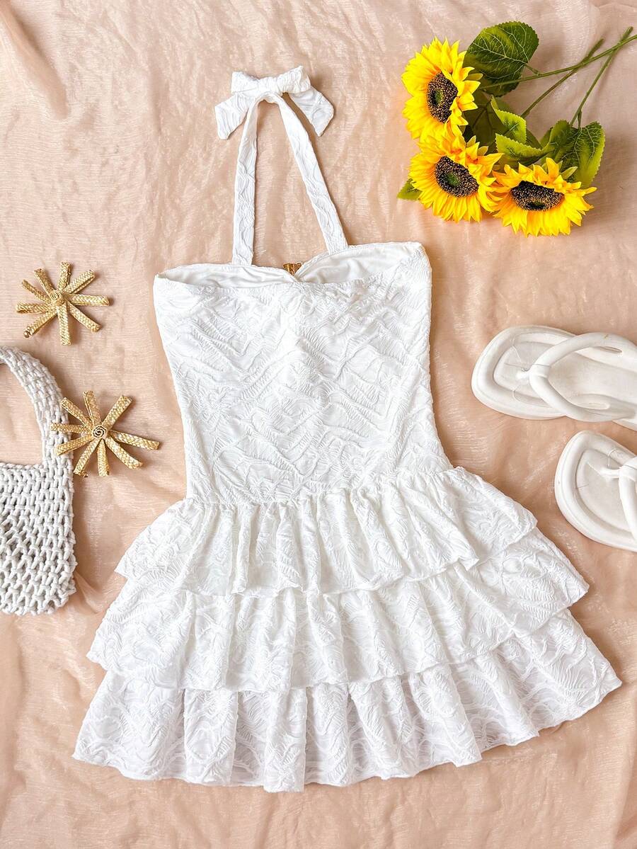 Tween girls blue and white floral halter sundress with shirred detail, sleeveless cami style, high waist, and tiered ruffle hem for vacation wear