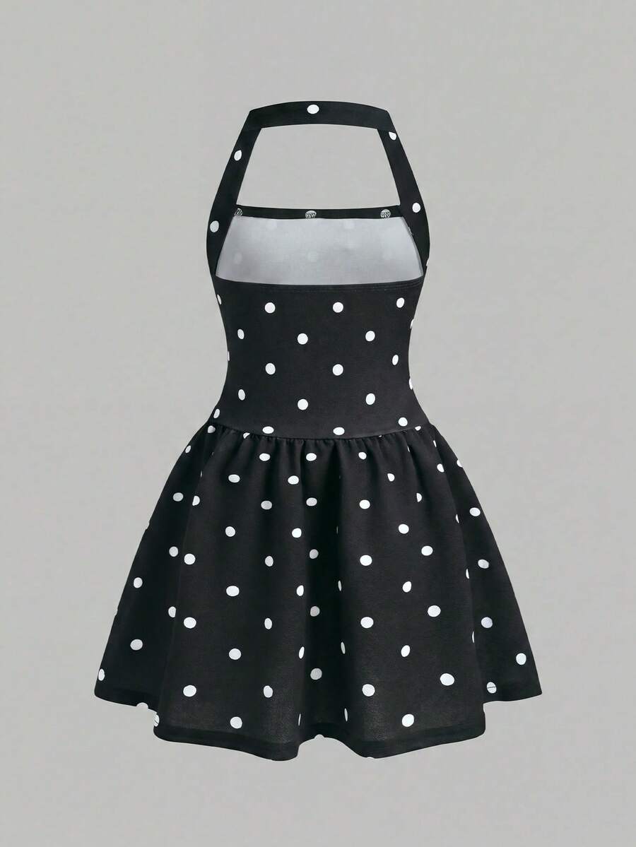 Black sleeveless halter polka dot mini dress for tween girls featuring a high waist and flared hem