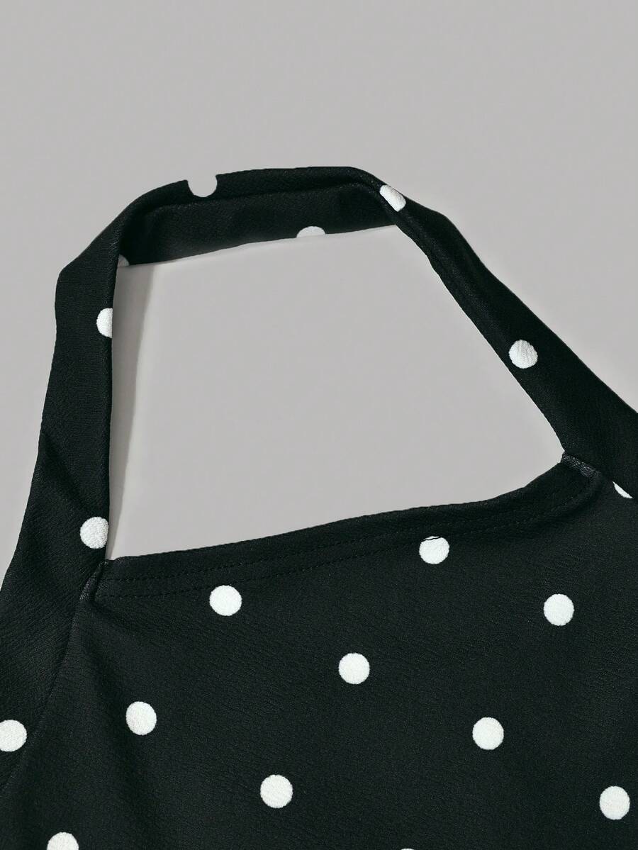 Black sleeveless halter polka dot mini dress for tween girls featuring a high waist and flared hem