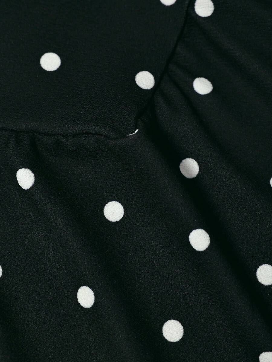 Black sleeveless halter polka dot mini dress for tween girls featuring a high waist and flared hem