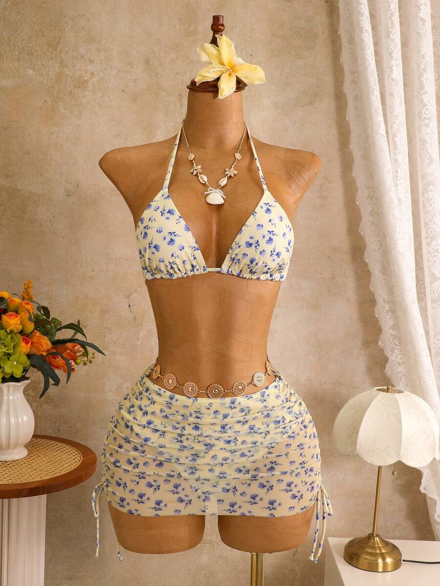 Women's black 3-piece bikini set featuring a halter triangle top with removable padding, high-waisted bottoms, and a knee-length mesh skirt with tie details.